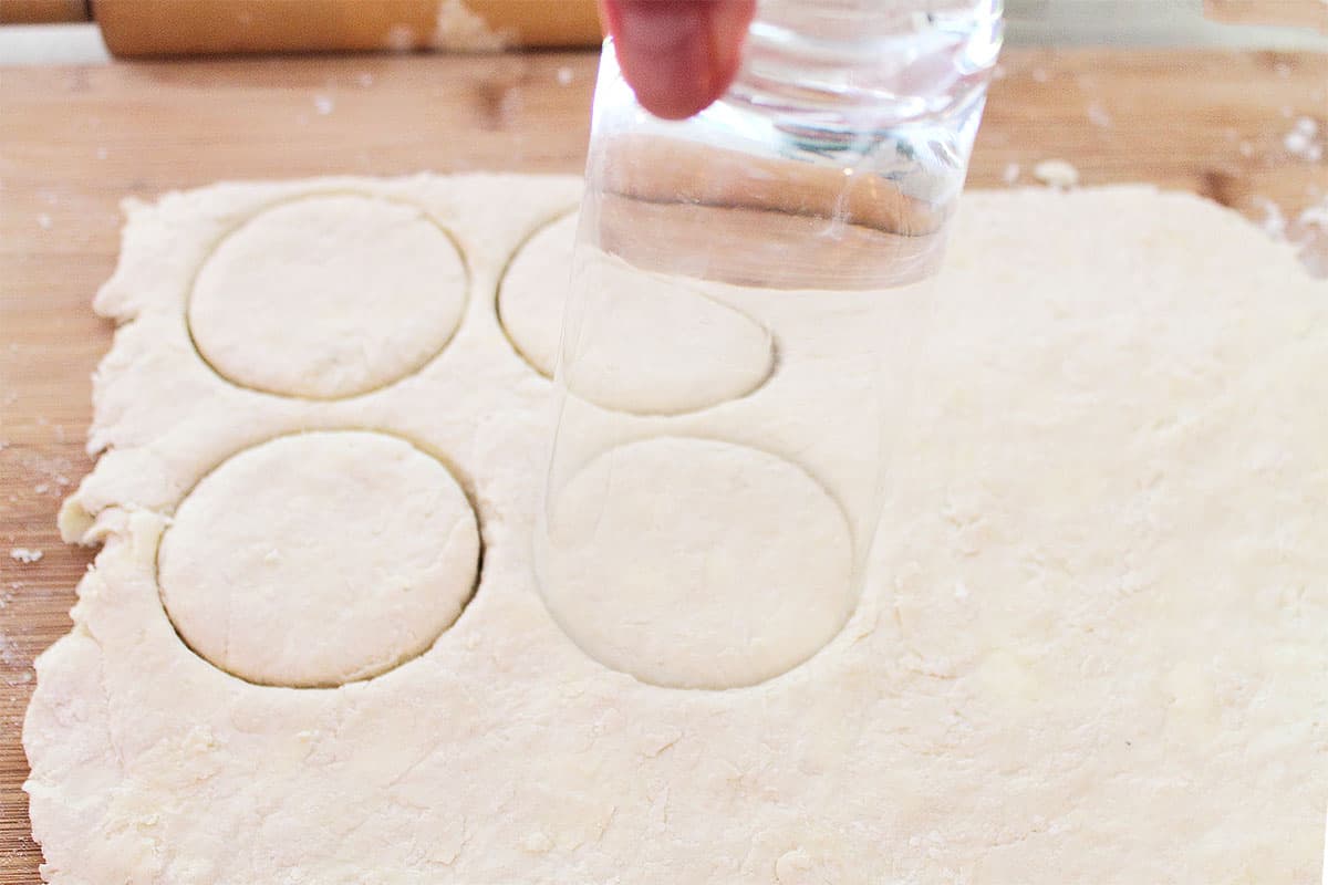 Cutting rounds of dough with glass.