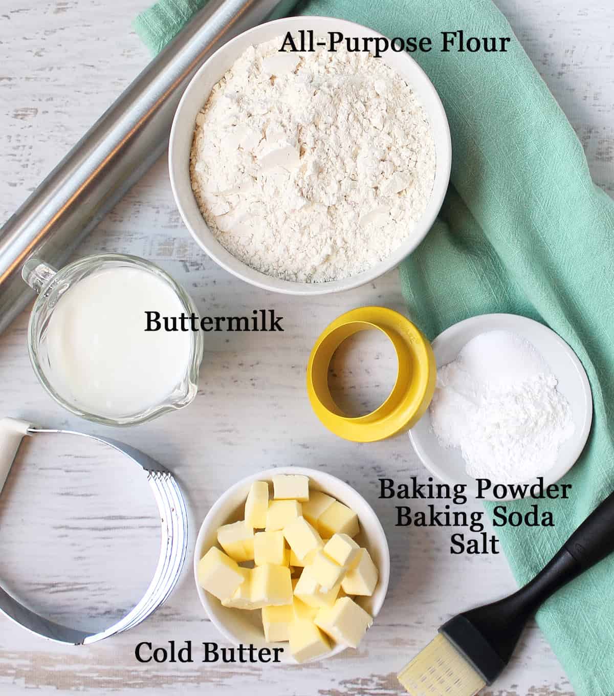 Ingredients for southern buttermilk biscuits on white table, labeled.