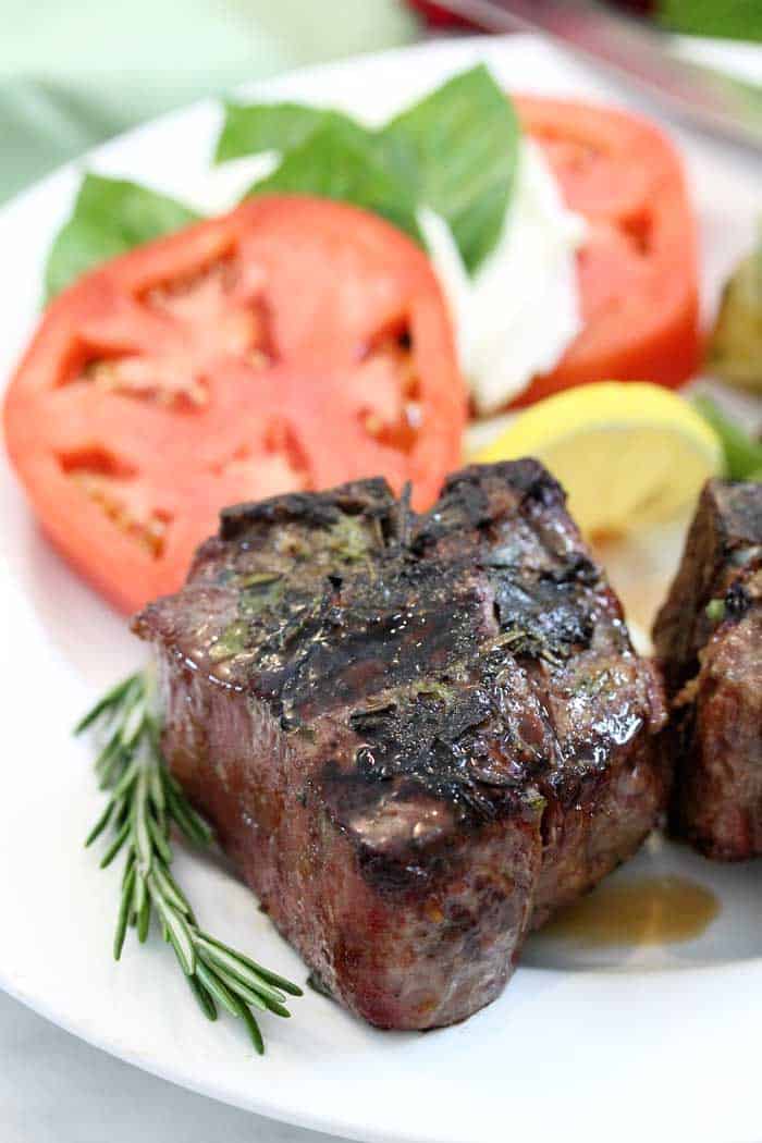 Closeup of lamb chop on white plate.