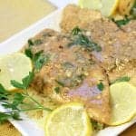 Closeup of a platter of lemon chicken with lemon slice garnishes.