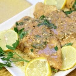 Closeup of a platter of lemon chicken with lemon slice garnishes.