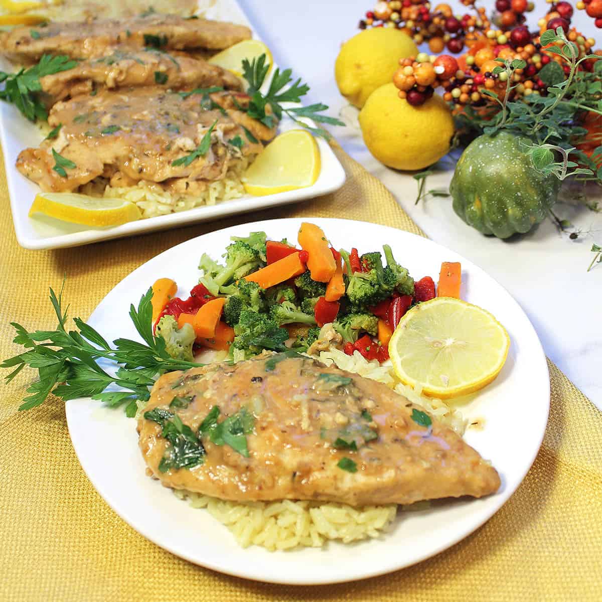 Finished chicken dinner on white plate with serving of vegetables.
