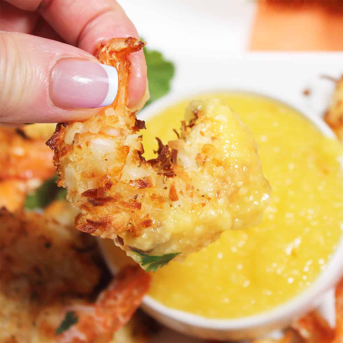 Holding shrimp covered in mango sauce.