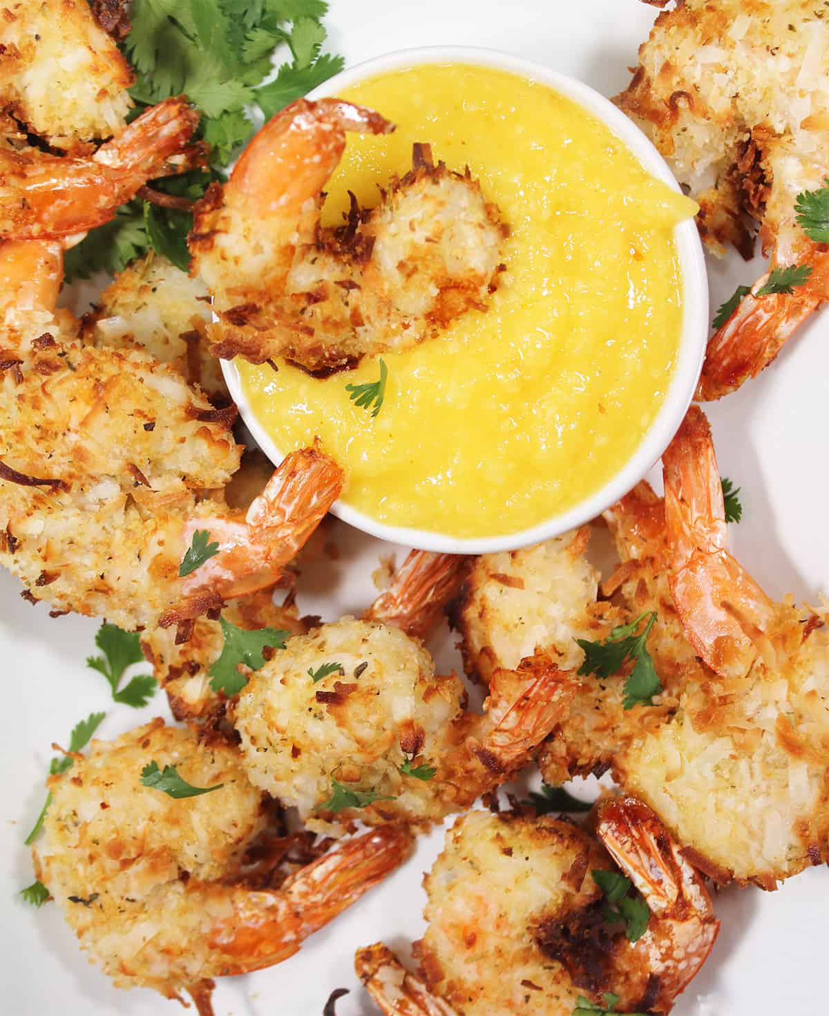 Shrimp in dipping sauce surrounded by other shrimp.