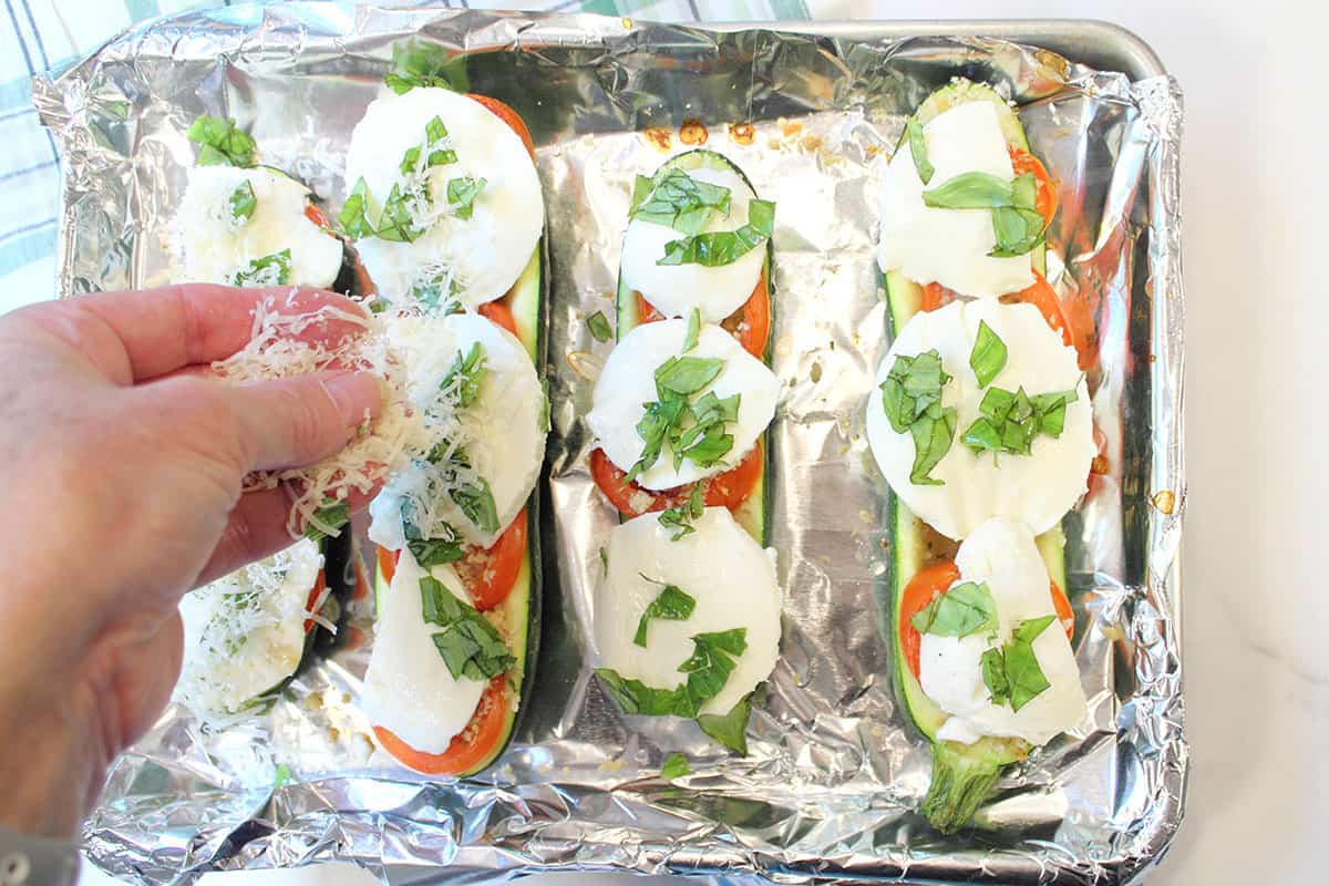 Sprinkle basil and parmesan cheese on top of mozzarella.