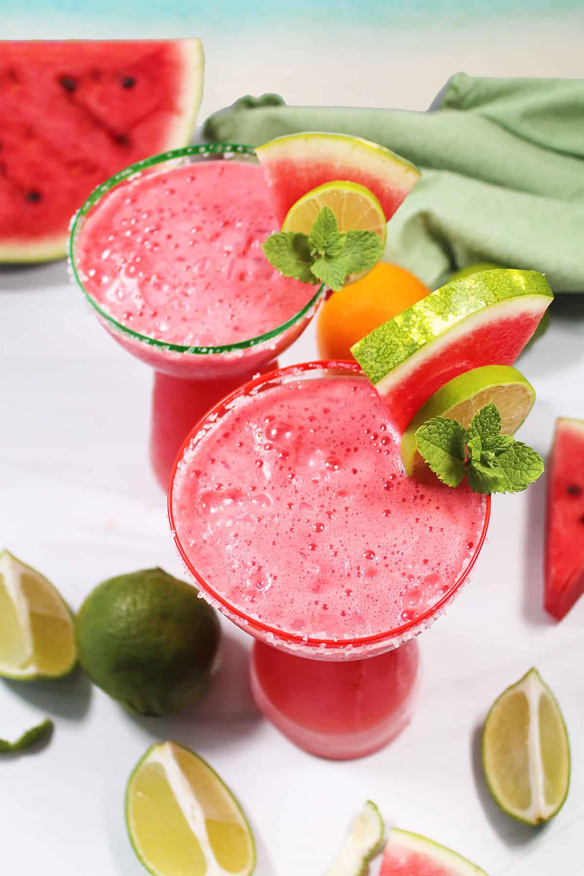 Watermelon Margaritas on the rocks with fruit and mint garnish.