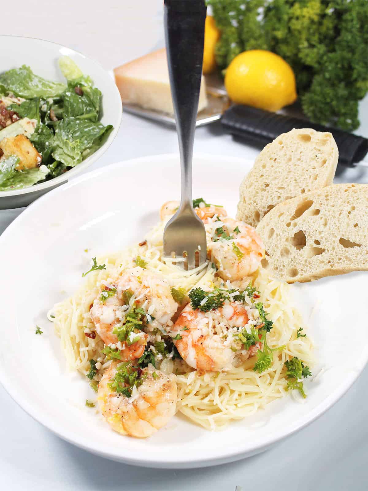 White Wine Shrimp Pasta dinner with bread, salad and wine.