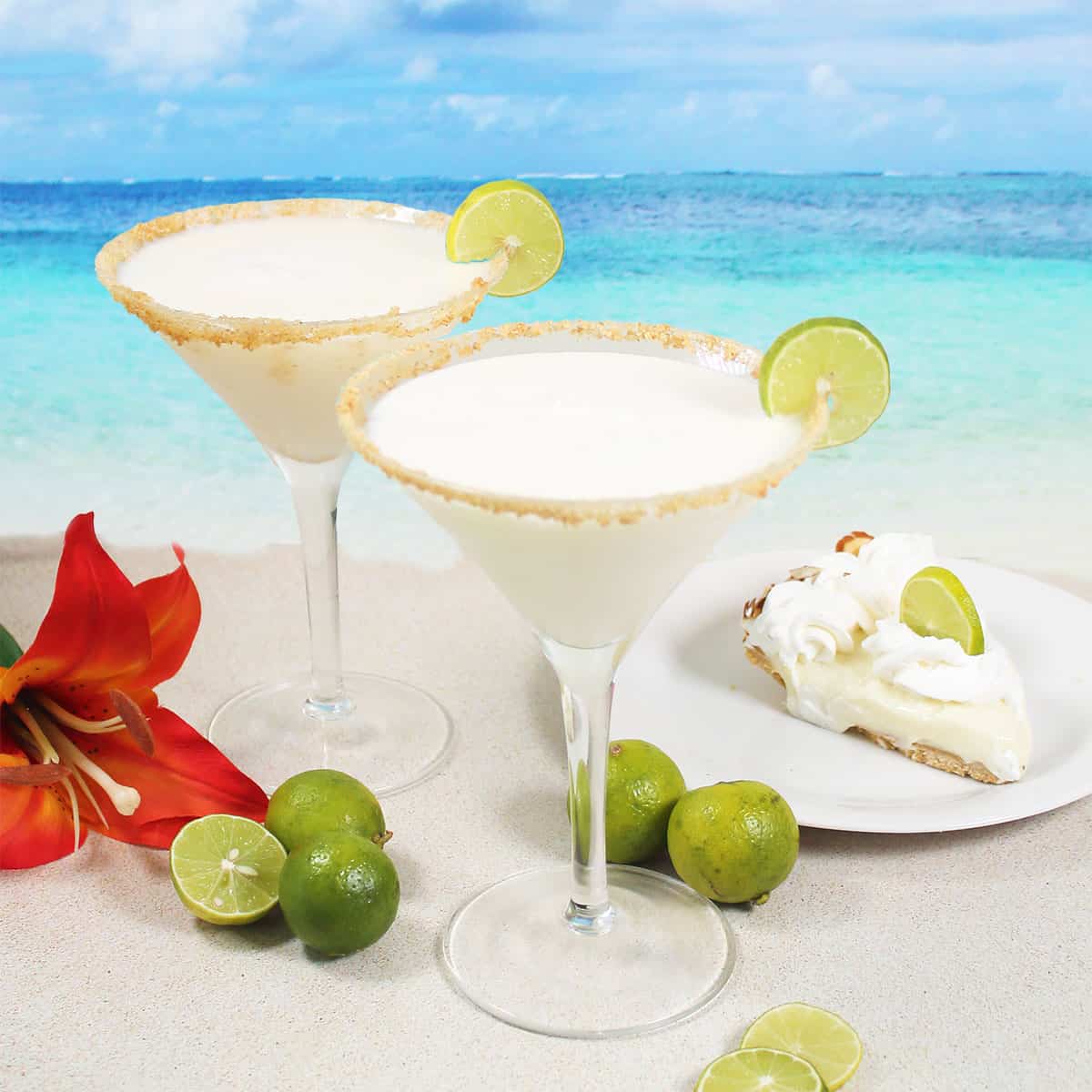 Two key lime pie martinis with lime wheel and graham cracker rim.