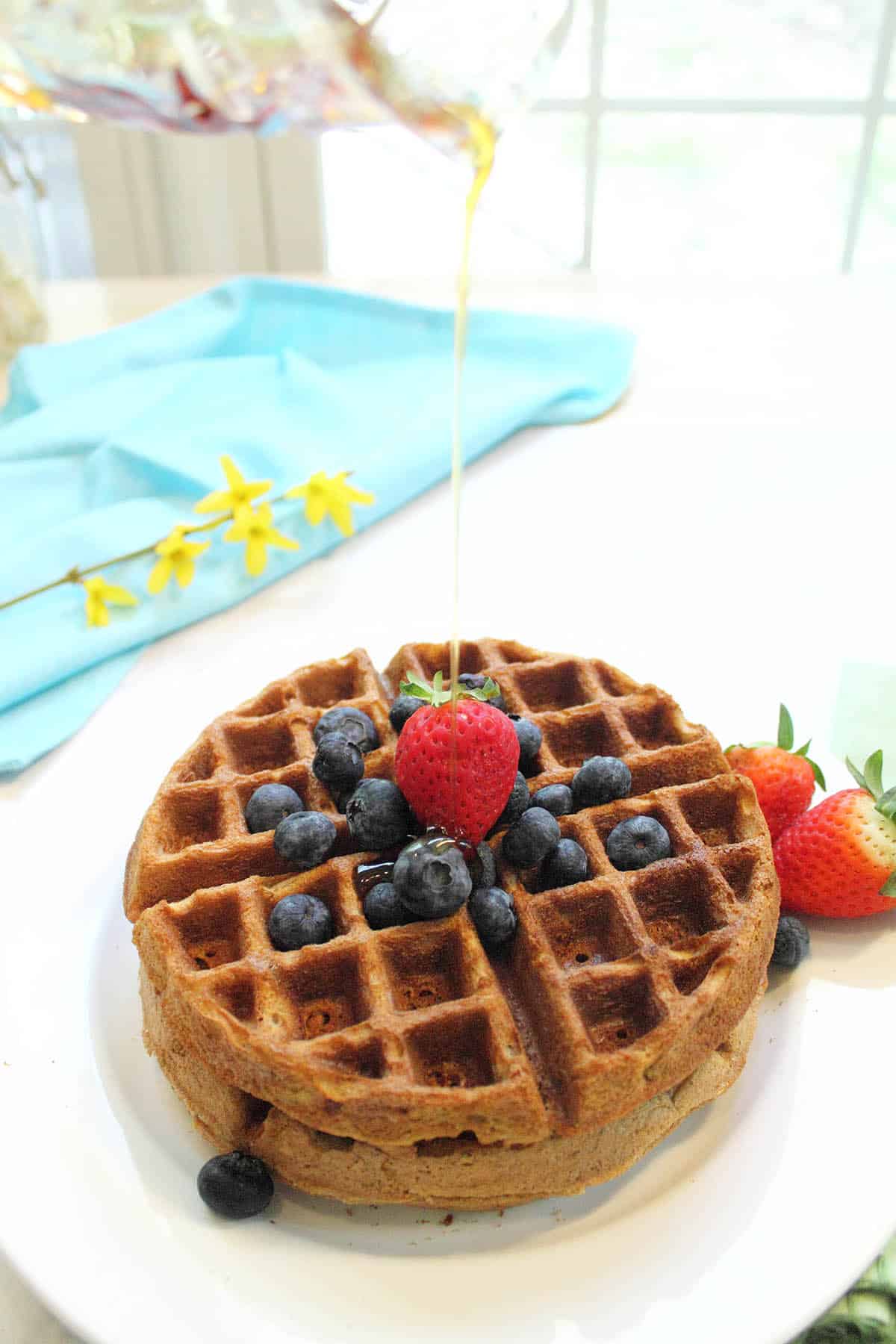 Pouring syrup on plated waffles.
