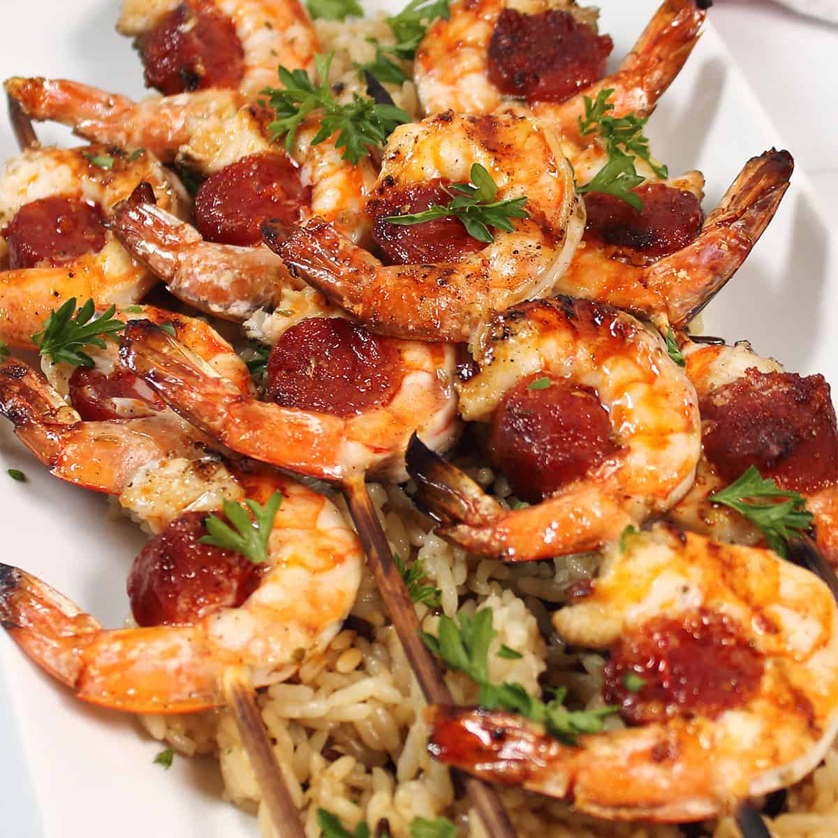 Closeup of grilled skewers on bed of rice.