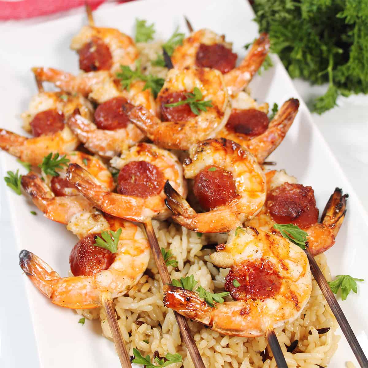 Shrimp and chorizo skewers served on a bed of rice.