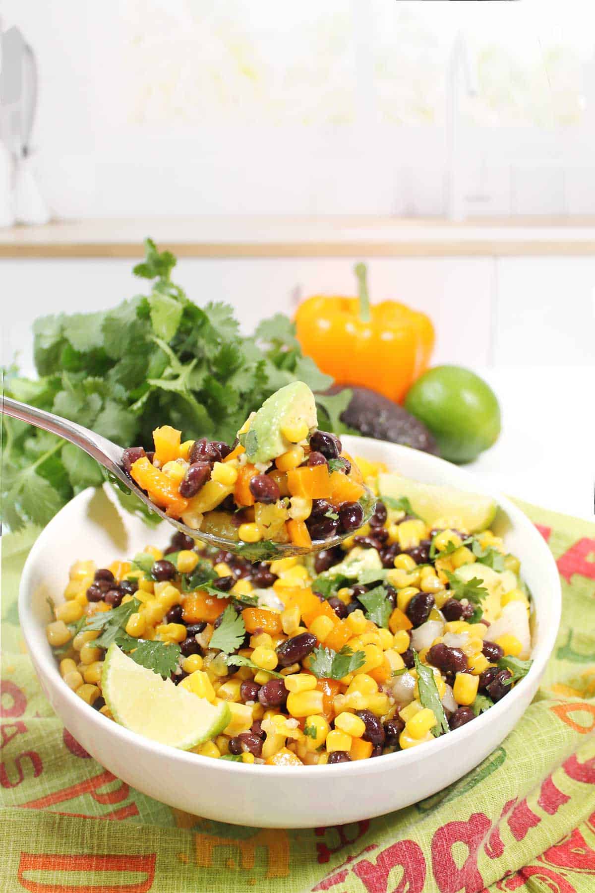 Lifting a spoonful of southwest black bean salad from bowl.