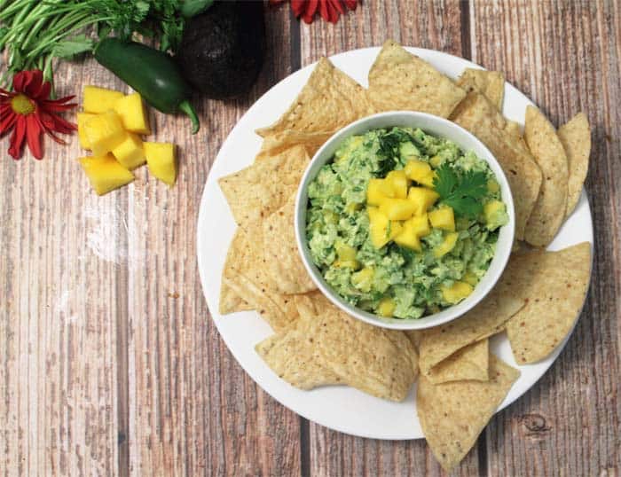 Mango Pineapple Guacamole in bowl with chips overhead