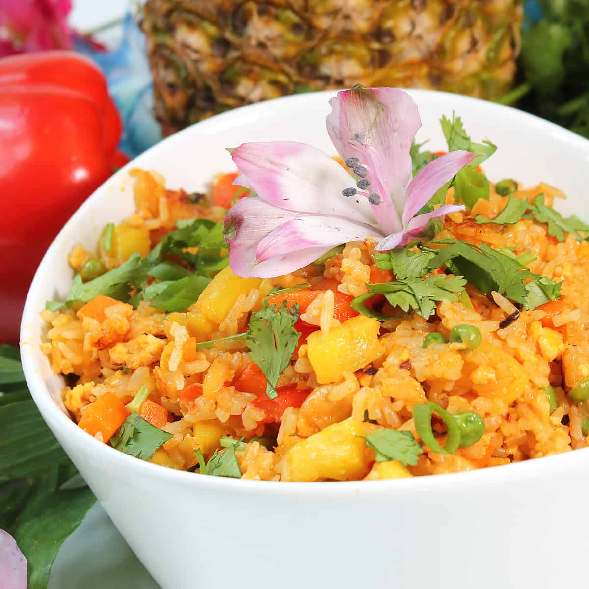 Partial view of pineapple fried rice in bowl with flower.