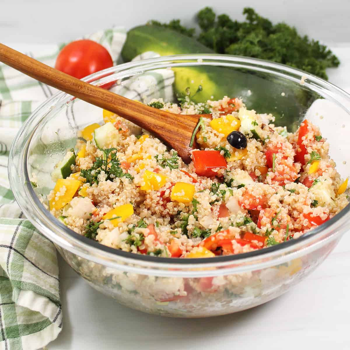 Quinoa Tabbouleh in serving bowl with wooden spoon.