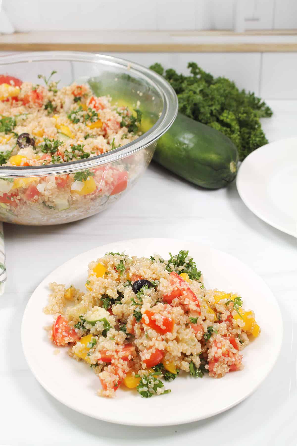 Plated serving of tabouli with bowl in back.
