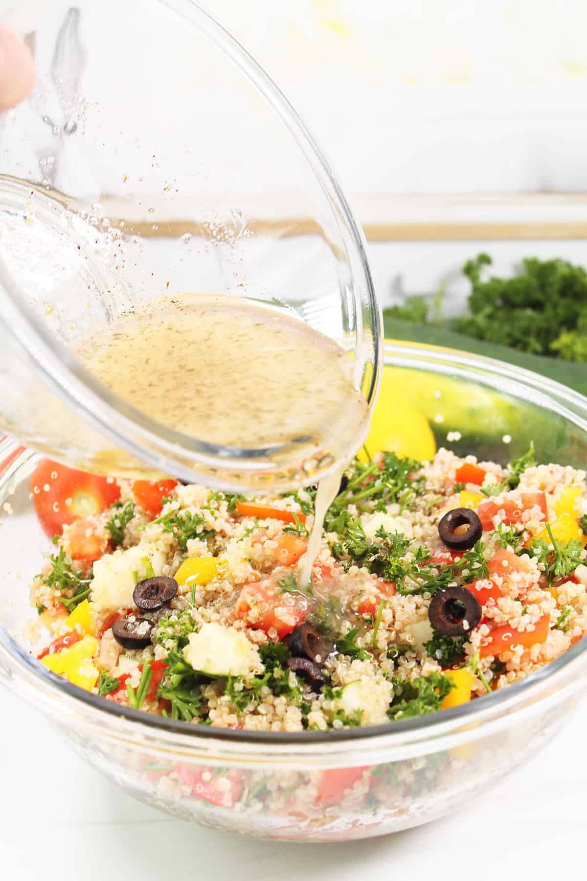 Pouring dressing on tabouleh salad with quinoa.