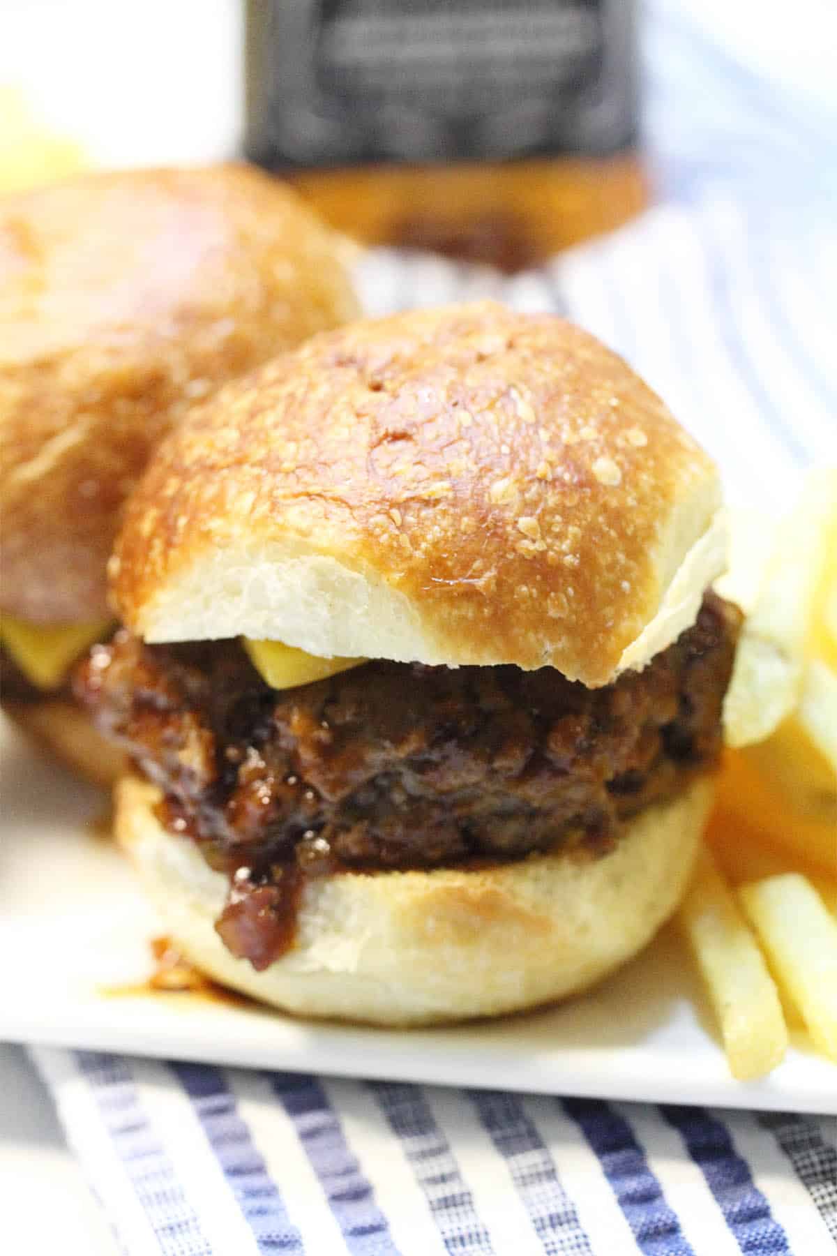 Closeup of single slider on bun on white plate.