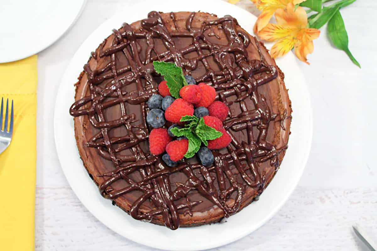 Overhead of decorated Kahlua Cheesecake on white plate.