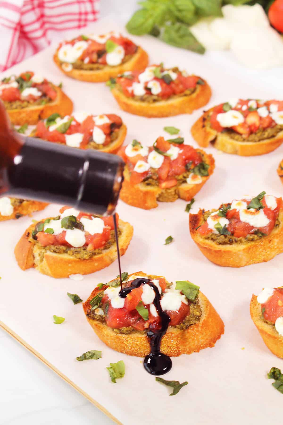 Drizzling balsamic over warm bruschetta.