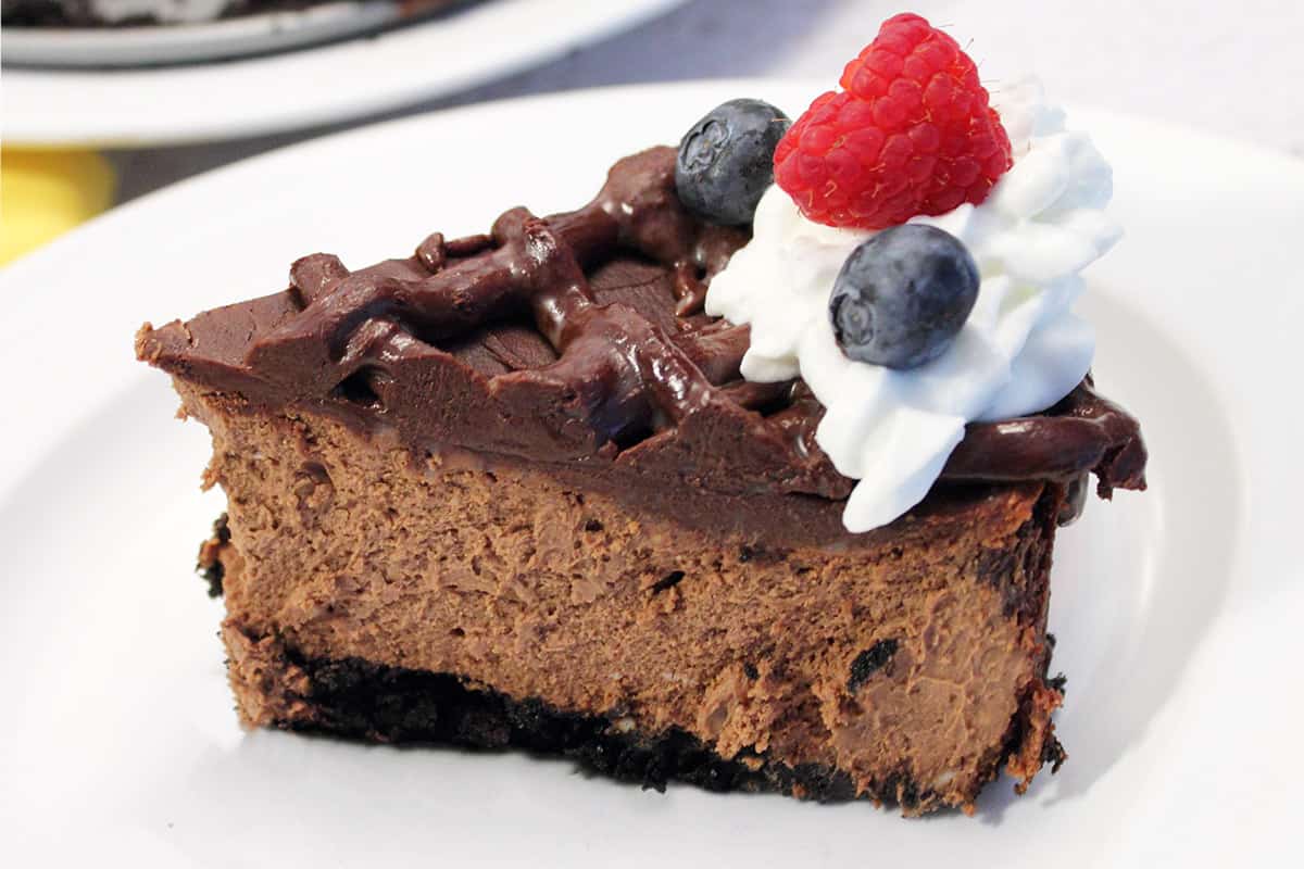 Slice of cheesecake on white plate.