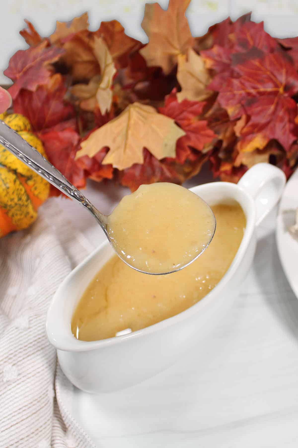 Holding ladle with gravy over gravy boat.