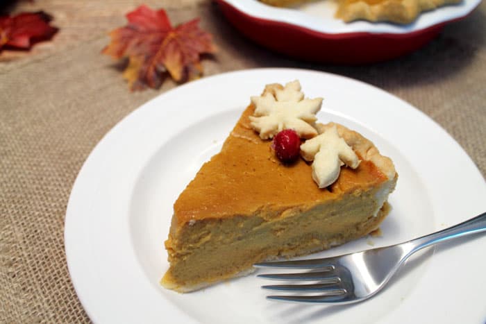 A slice of the best pumpkin pie on a white plate with fork.