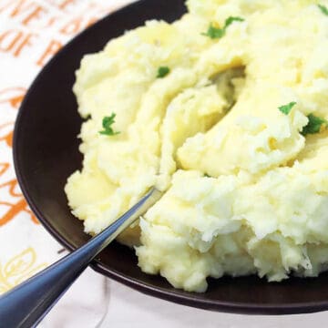 Spoon in a bowl of mashed potatoes.
