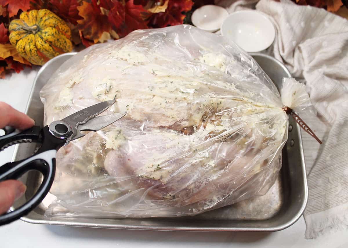 Snipping holes in cooking bag.