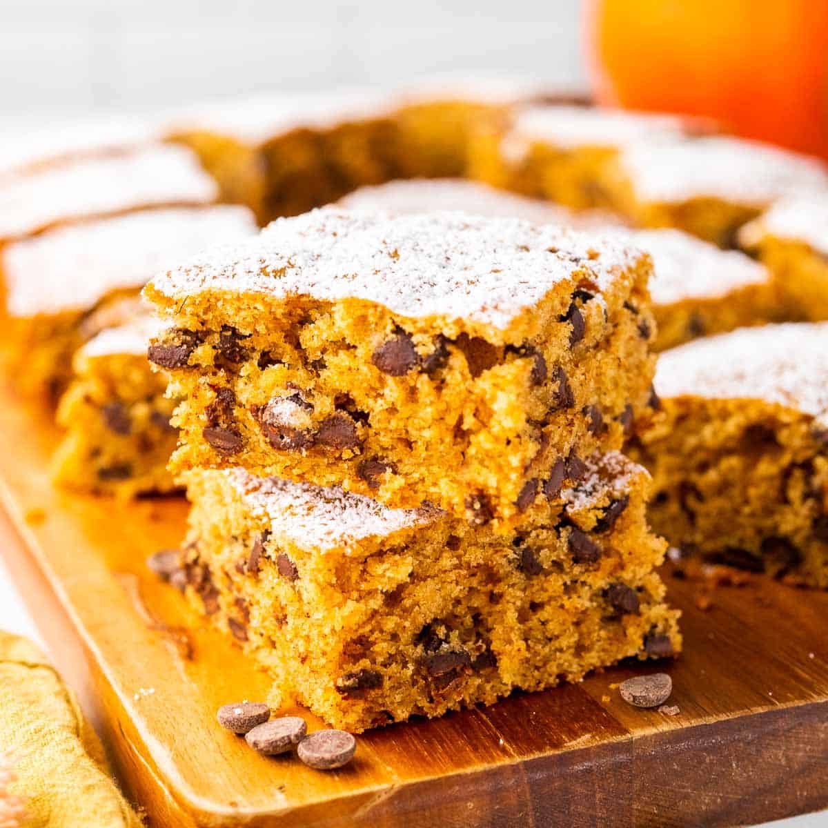 Closeup of pumpkin bars on wooden board.