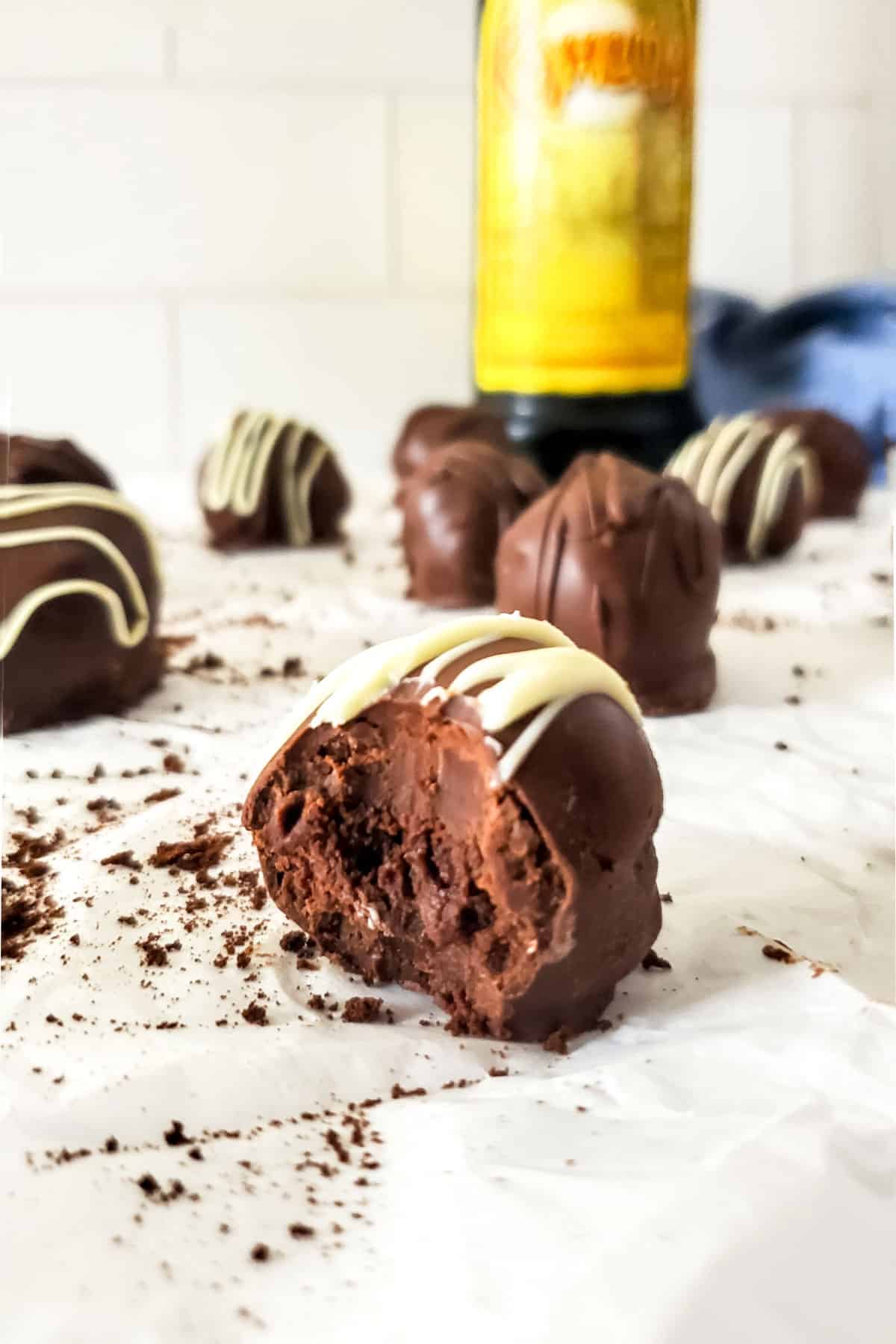 Bite out of truffle in front of Kahlua bottle.