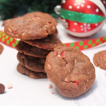 Stacked chocolate peppermint chip cookies with ornament.