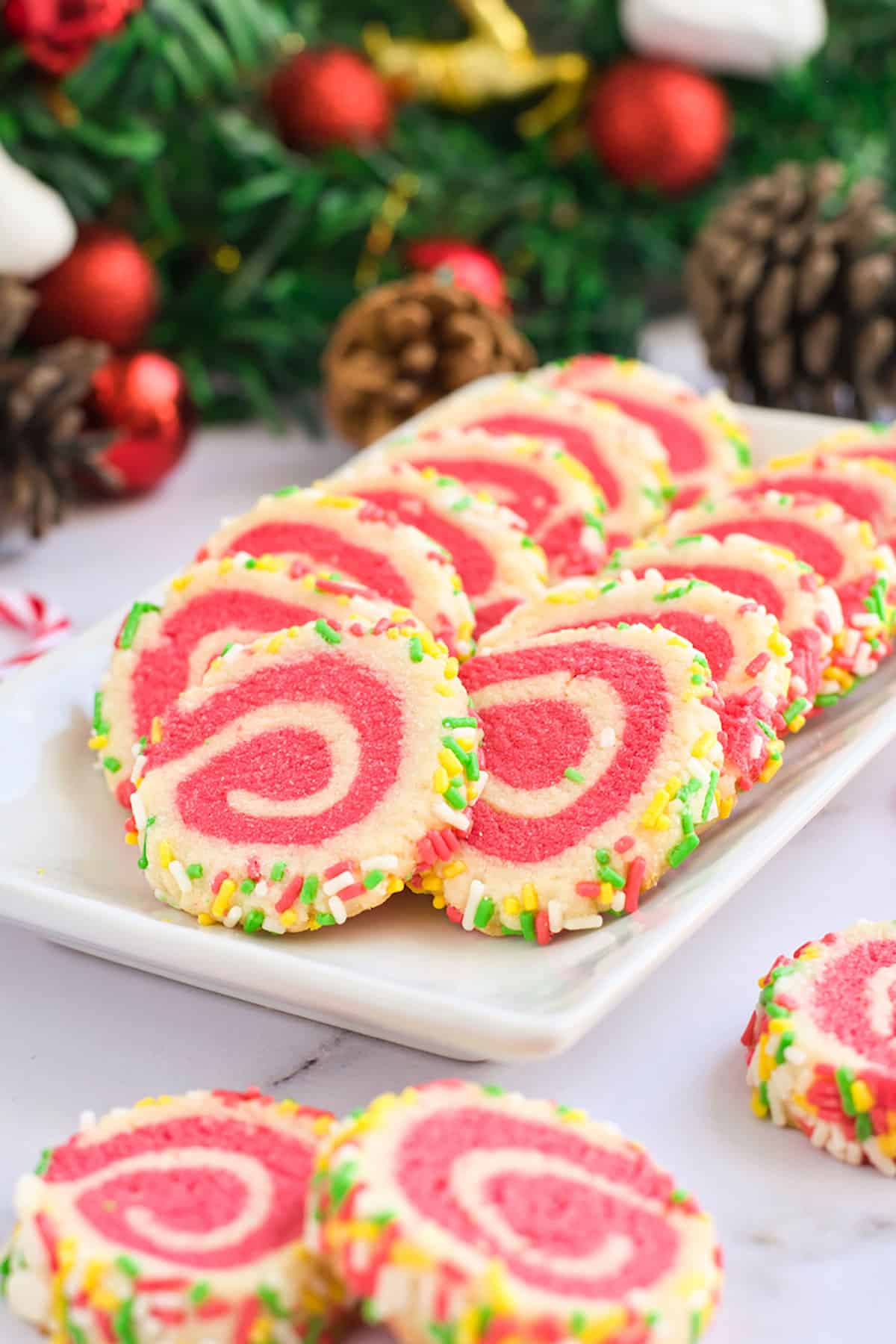 Closeup of peppermint pinwheel cookies on white plate.