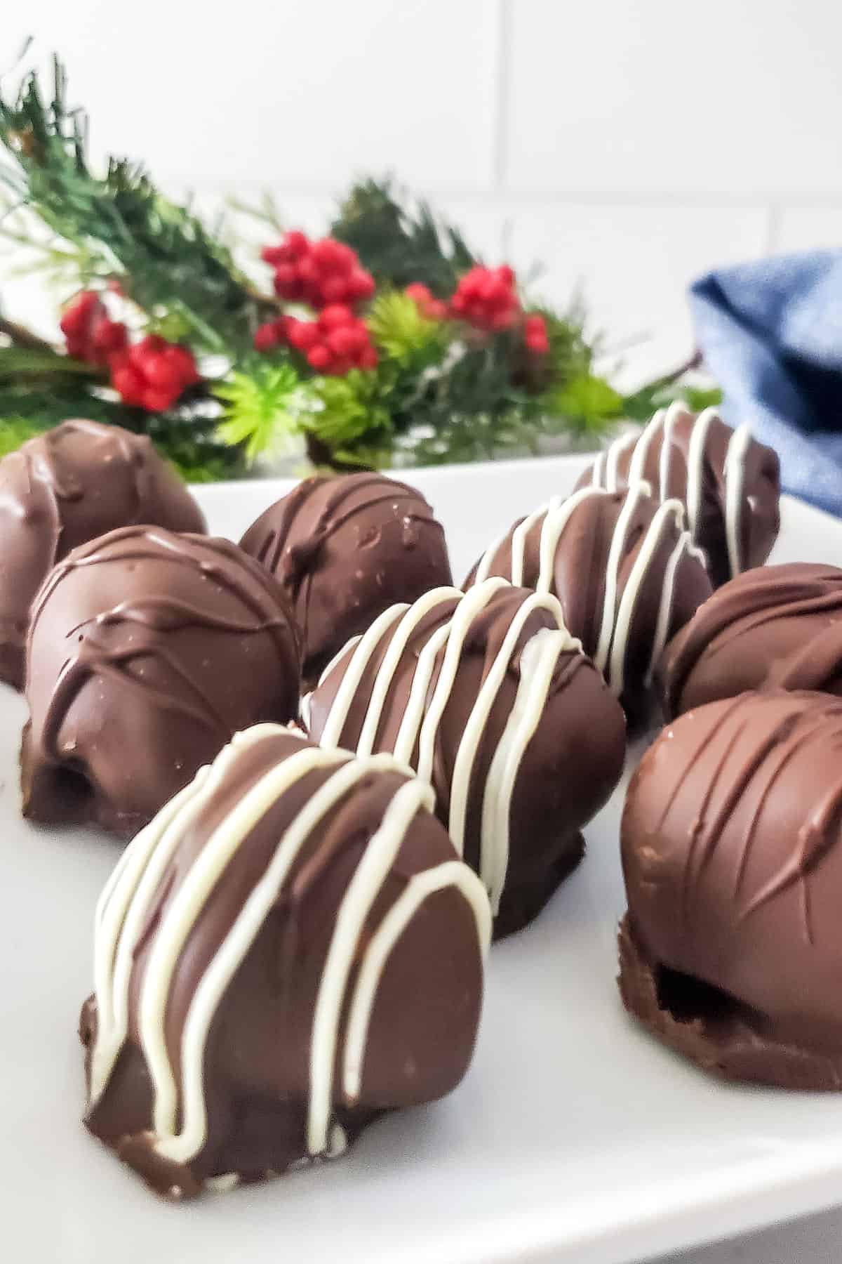 Closeup of drizzled Kahlua truffles on white plate.