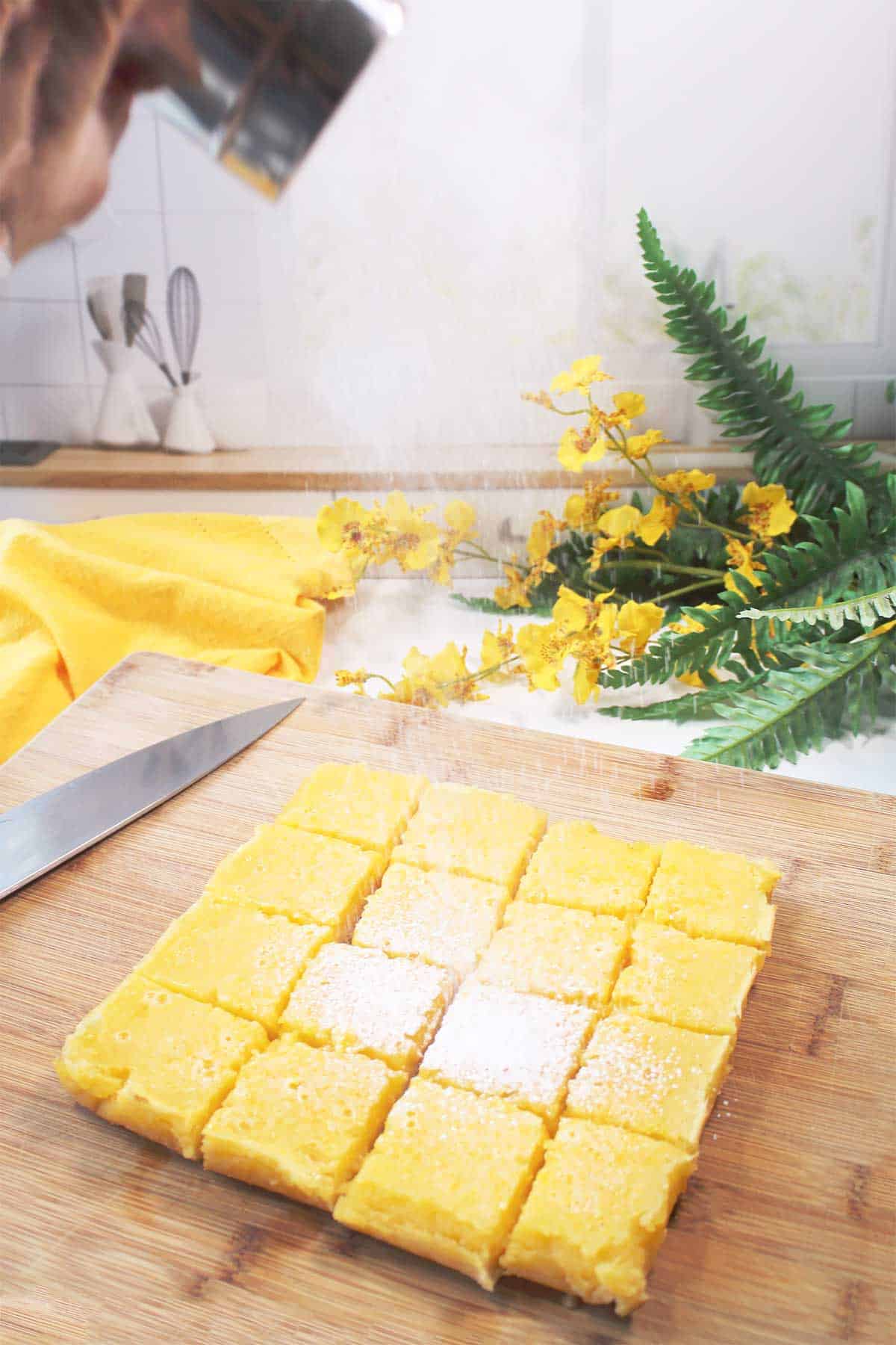 Dusting lemon bars with powdered sugar.