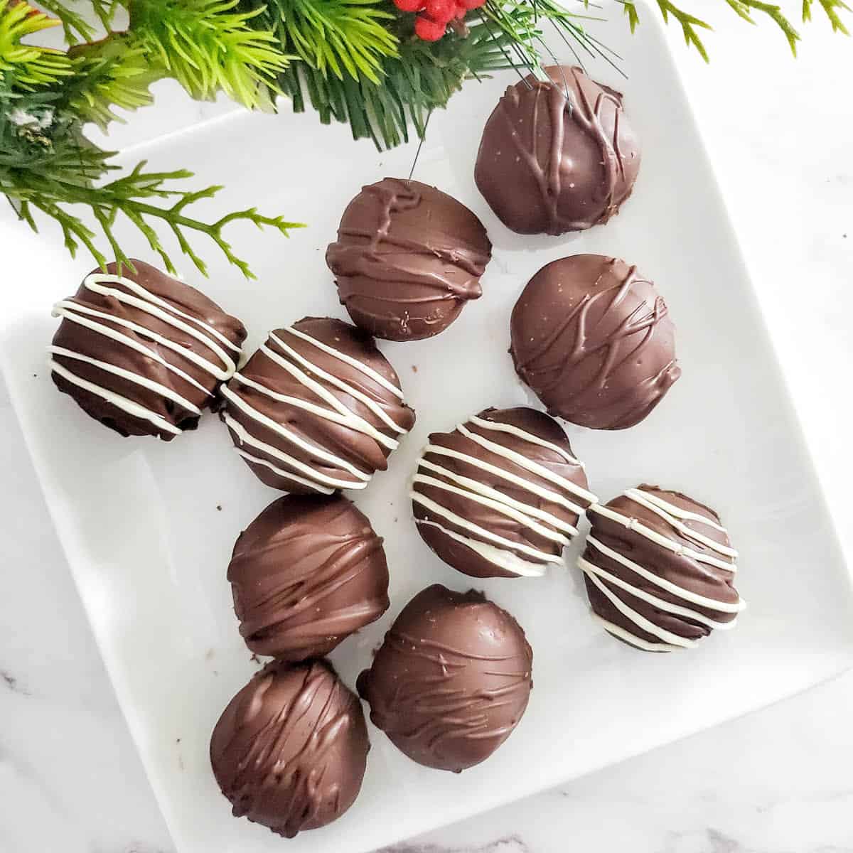 Overhead of finished kahlua truffles on white plate.