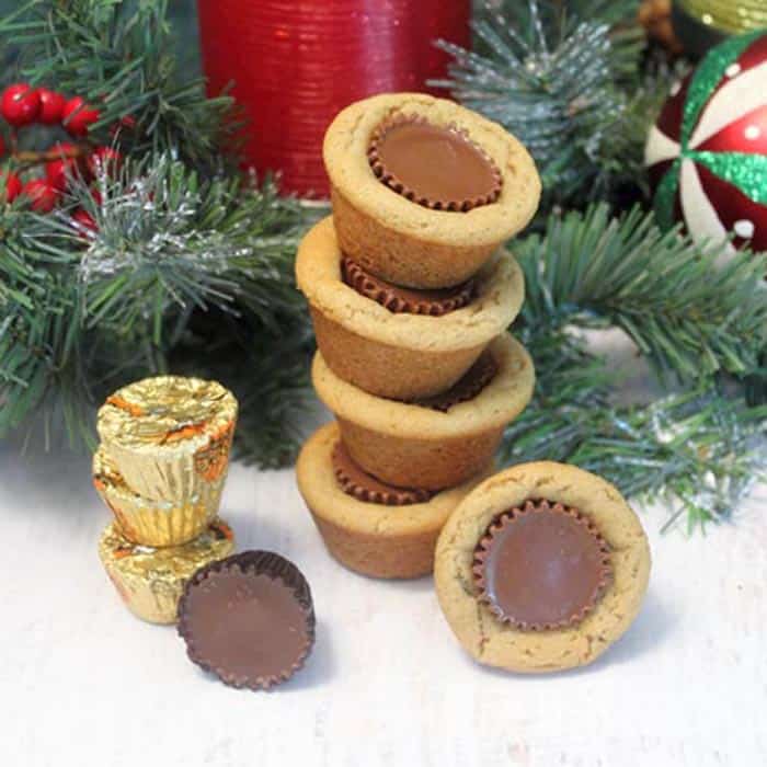 Stacked Peanut Butter Cup Cookies with Christmas greenery and ornaments in background.