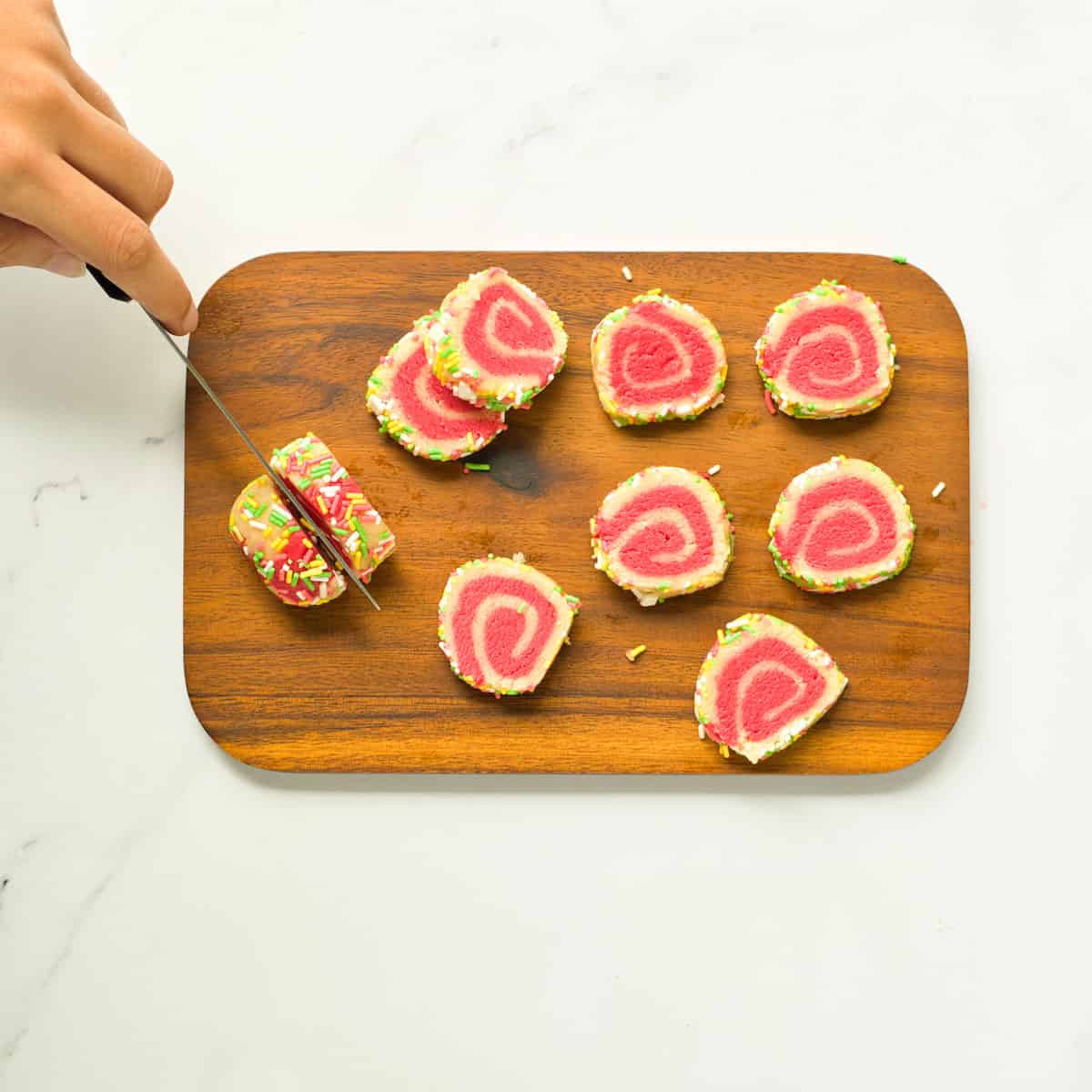 Slicing pinwheel swirl cookies.