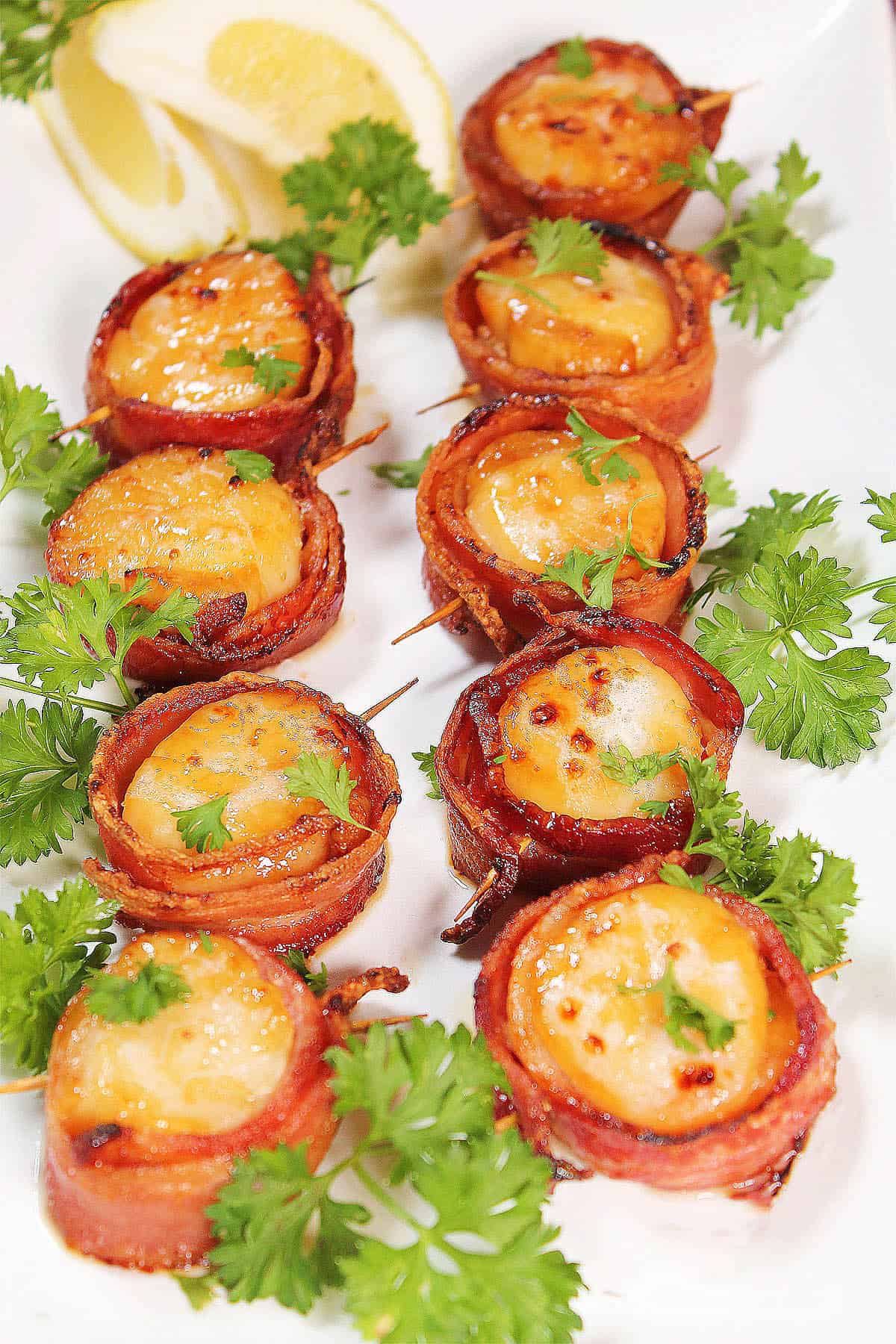 Air Fryer Bacon Wrapped Scallops on platter with parsley garnish.