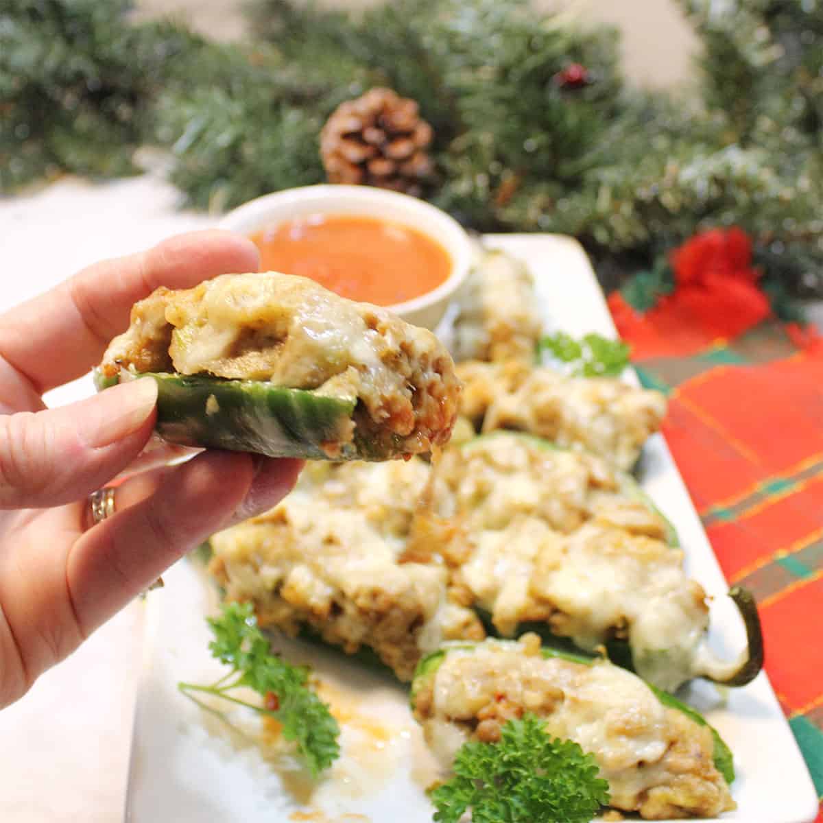 Bite of jalapeno popper over plateful.