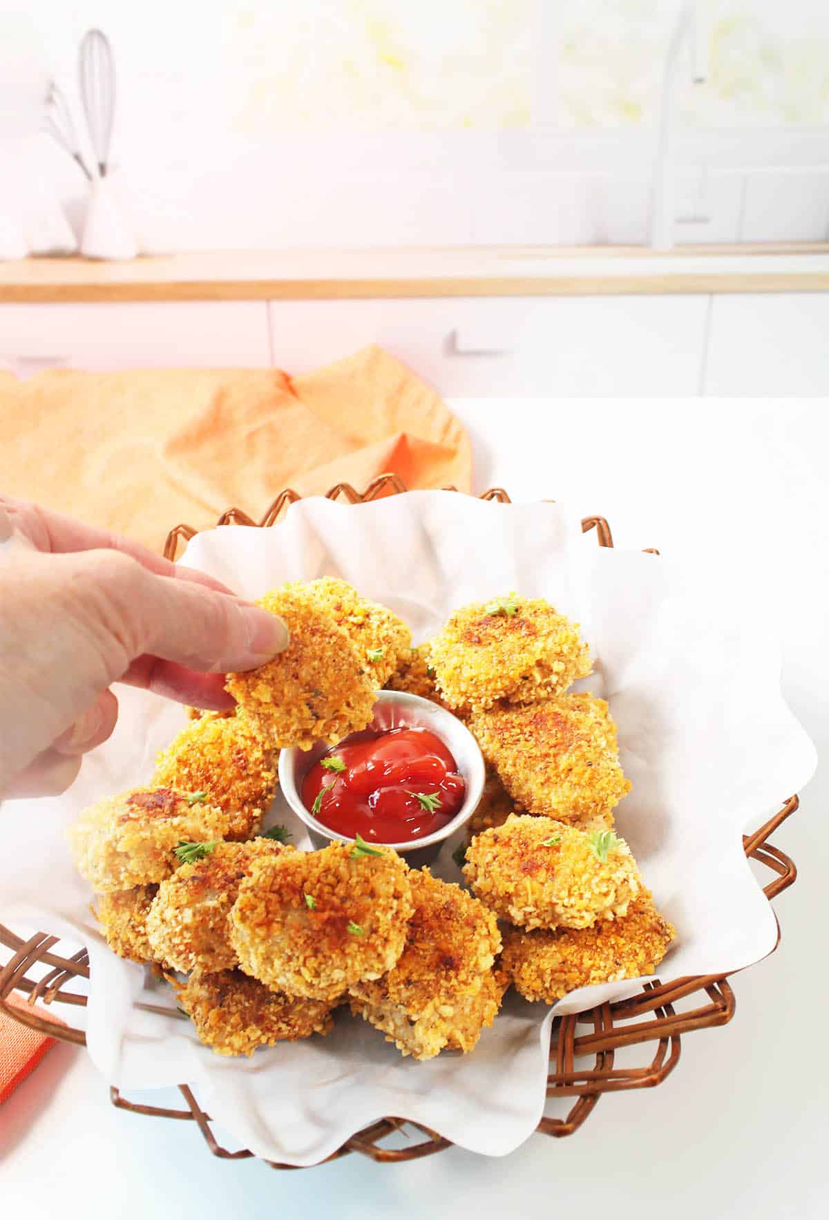 Dipping chicken nuggets for toddlers into ketchup.