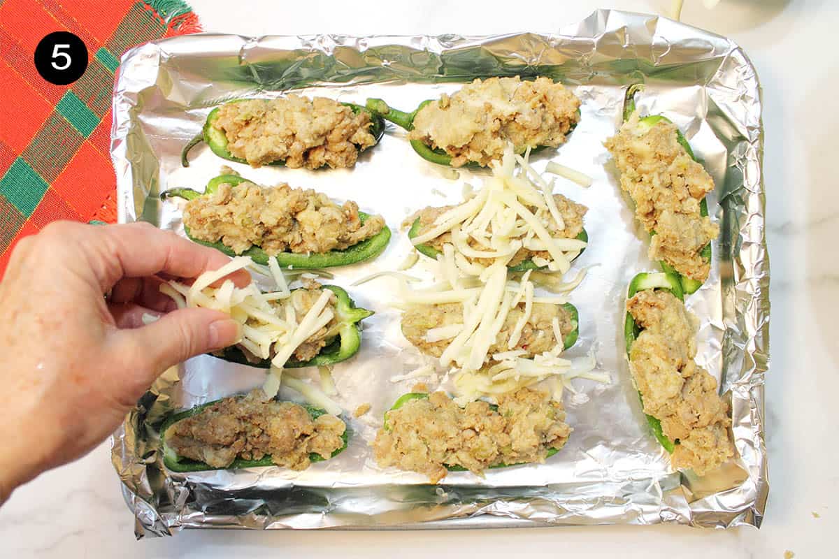 Sprinkling poppers with cheese.
