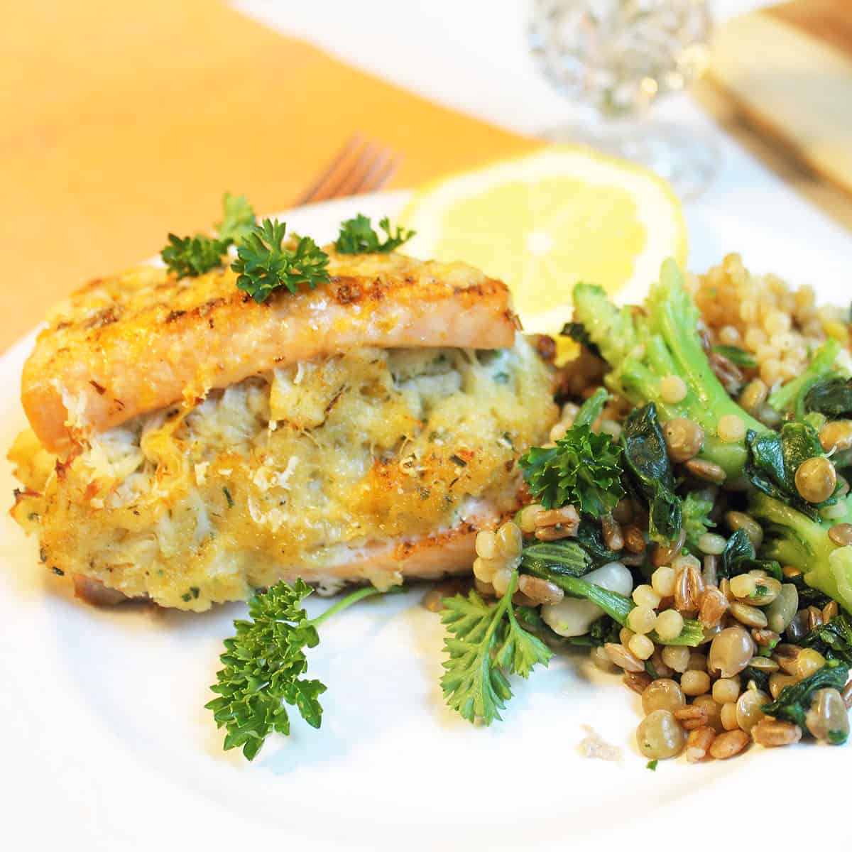 Closeup of crab stuffing in salmon on white plate.