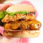Holding rodeo burger on bun.