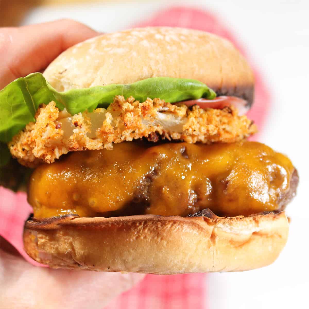 Holding rodeo burger on bun.
