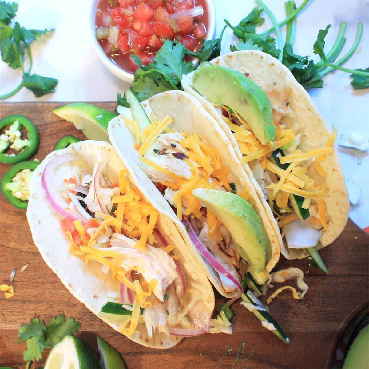 Overhead of tacos on board with fixings.