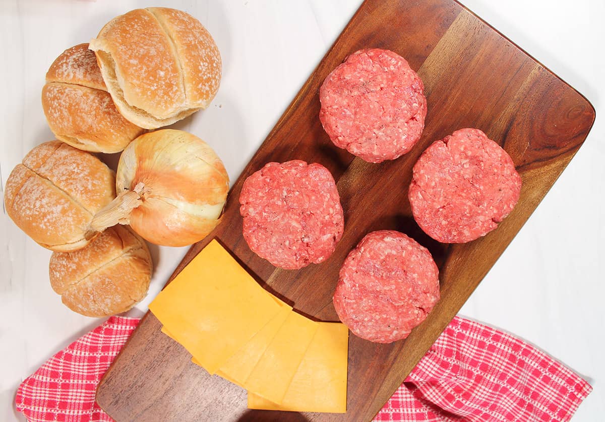 Shaped burgers with buns ready for grill.
