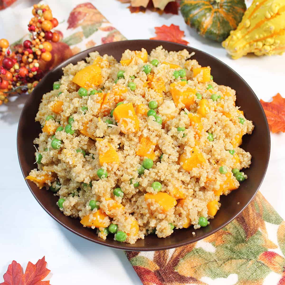 Bowl of pilaf on fall towel with gourds and fall leaves.