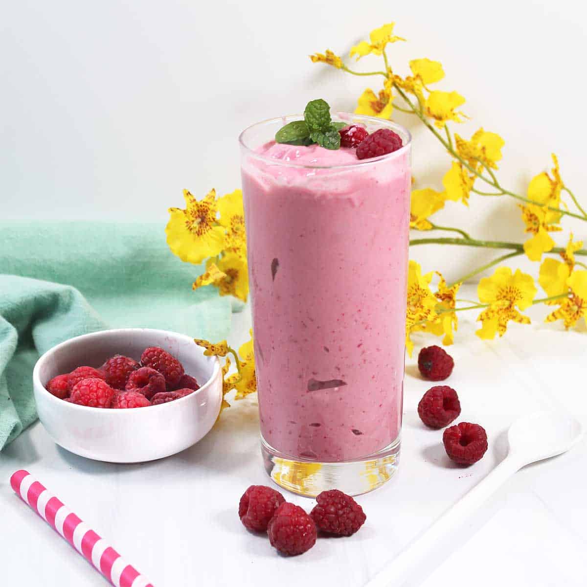 Smoothie in glass with yellow flowers.