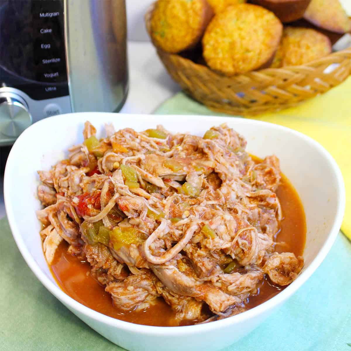 Cola Pulled Pork in bowl by Instant Pot and corn muffins.